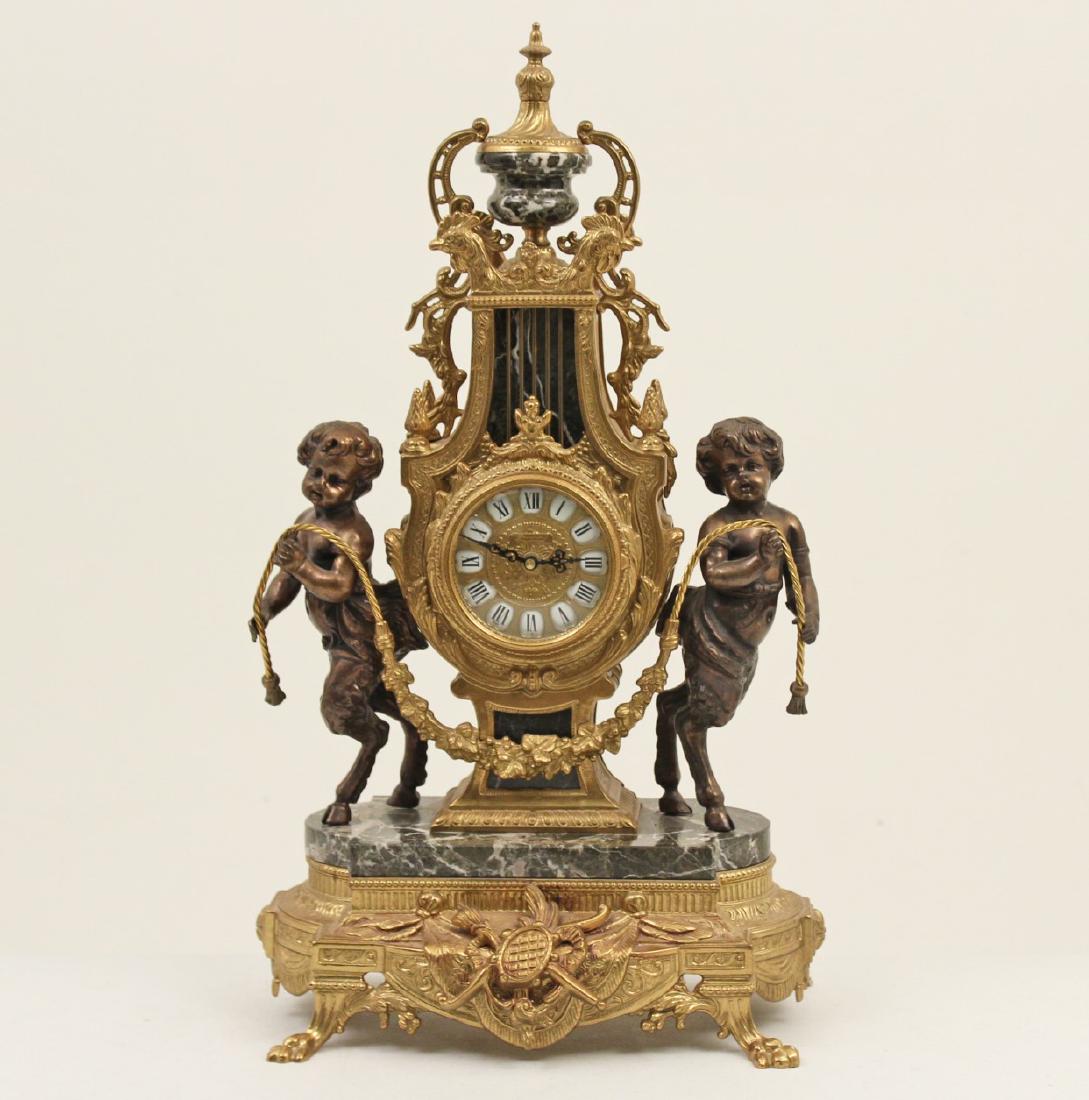 FRENCH STYLE GILT METAL AND BLACK MARBLE CLOCK: FRENCH STYLE GILT METAL AND BLACK MARBLE CLOCK HAVING "CLODION" INSPIRED PUTTI FIGURE SURMOUNTS WITH HOOF FOOT HOLDING FOLIATED VINE SURROUNDING LYRE FORMED CLOCK WITH ROOSTER HEADS AND URN FINIAL RES