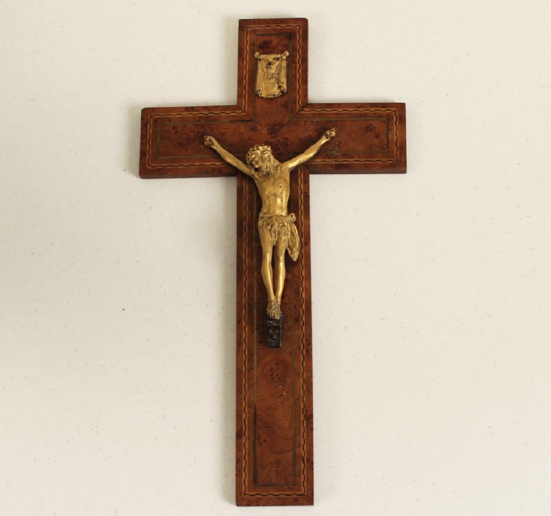 GILT BRONZE CRUCIFIX MOUNTED TO AMBOYNA: GILT BRONZE CRUCIFIX MOUNTED TO AMBOYNA WITH FINE EBONY/SATINWOOD AND BRASS INLAID STAND; 15.75"H X 8.5"W; CONDITION: AREAS OF FINE BRASS INLAY MISSING