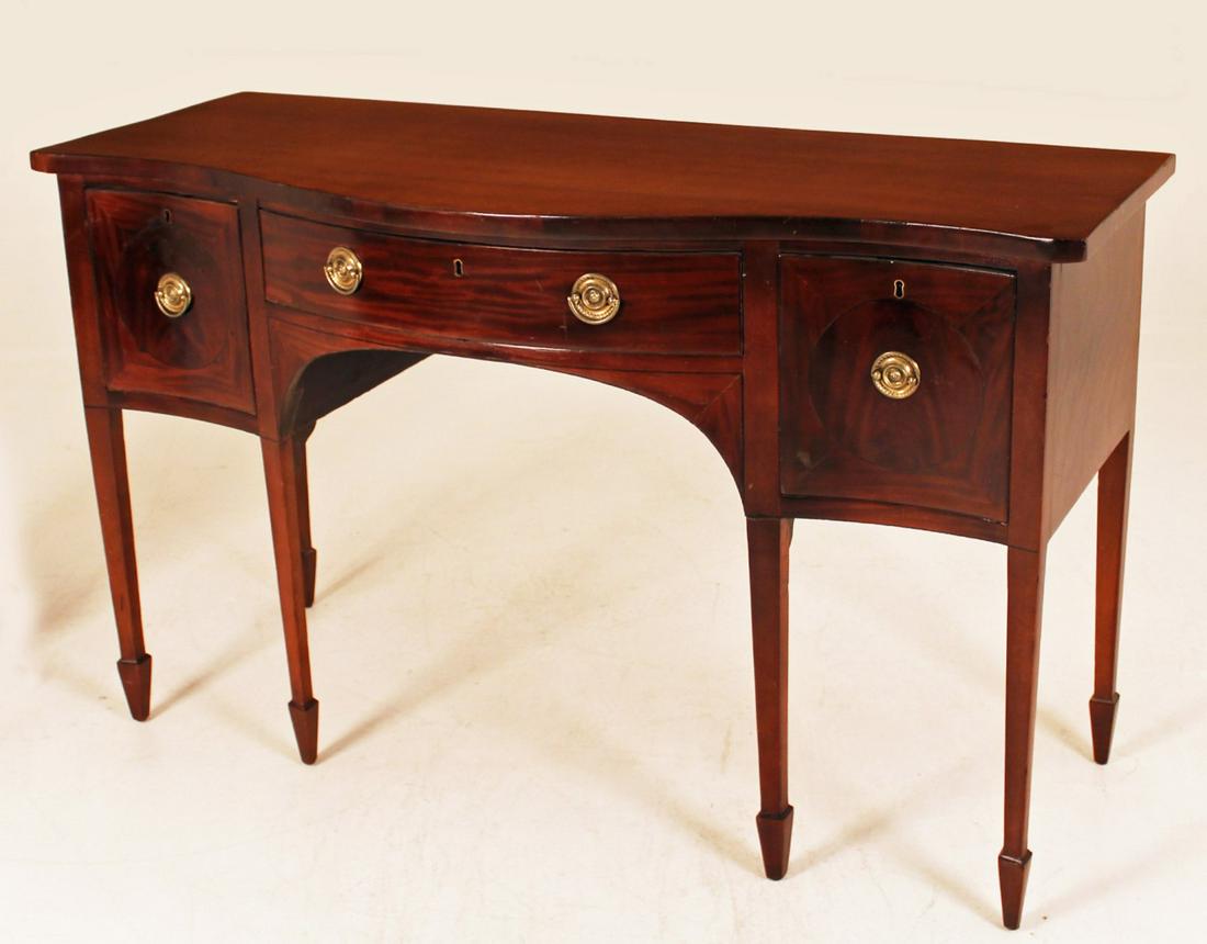 PETITE ENGLISH HEPPLEWHITE MAHOGANY SERPENTINE: PETITE ENGLISH HEPPLEWHITE MAHOGANY SERPENTINE SIDEBOARD HAVING 2 DEEP WINE DRAWERS AND ONE SILVER DRAWER RESTING ON TAPERD LEGS WITH SPADE FEET, 19TH C.; 36"H X 59.5"W X 24"D