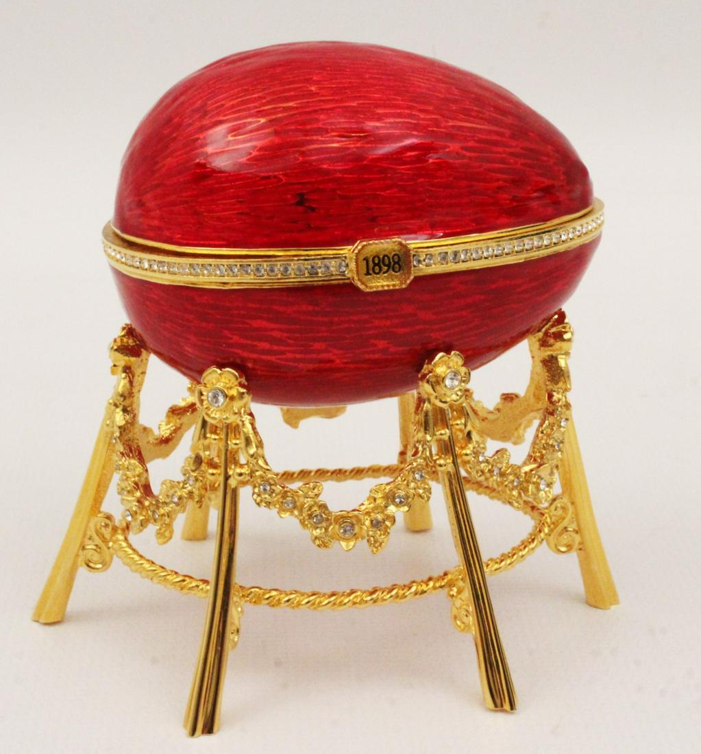 FABERGE IMPERIAL RED ENAMEL AND QUILLOCHE EGG: LICENSED RECREATED FABERGE QUILLOCHE AND RED ENAMEL OVERLAID IMPERIAL EGG ON GOLD GILT METAL AND JEWELED STAND OPENING TO REVEAL A GOLD WASH INTERIOR WITH HINGED CHICKEN FORMED BOX THAT OPENS TO REVEA