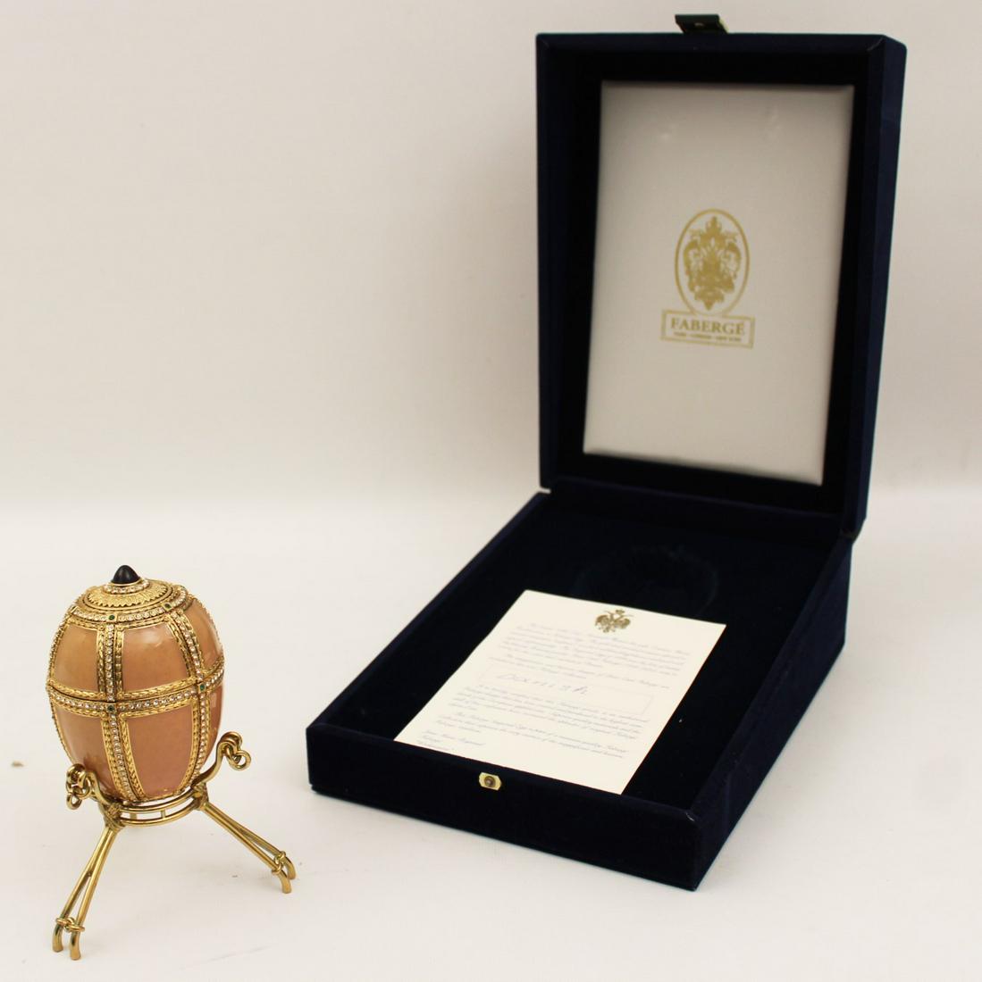 FABERGE "DANISH" IMPERIAL EGG: "DANISH" IMPERIAL EGG LICENSED AND RECREATED BY FABERGE HAVING PINK SALMON ENAMEL OVER GUILLOCHE WITH CHANNEL SET JEWELS HAVING HIGHLY GOLD GILT METAL TOP WITH RUBY COLORED POINTED STONE OPENING TO RE