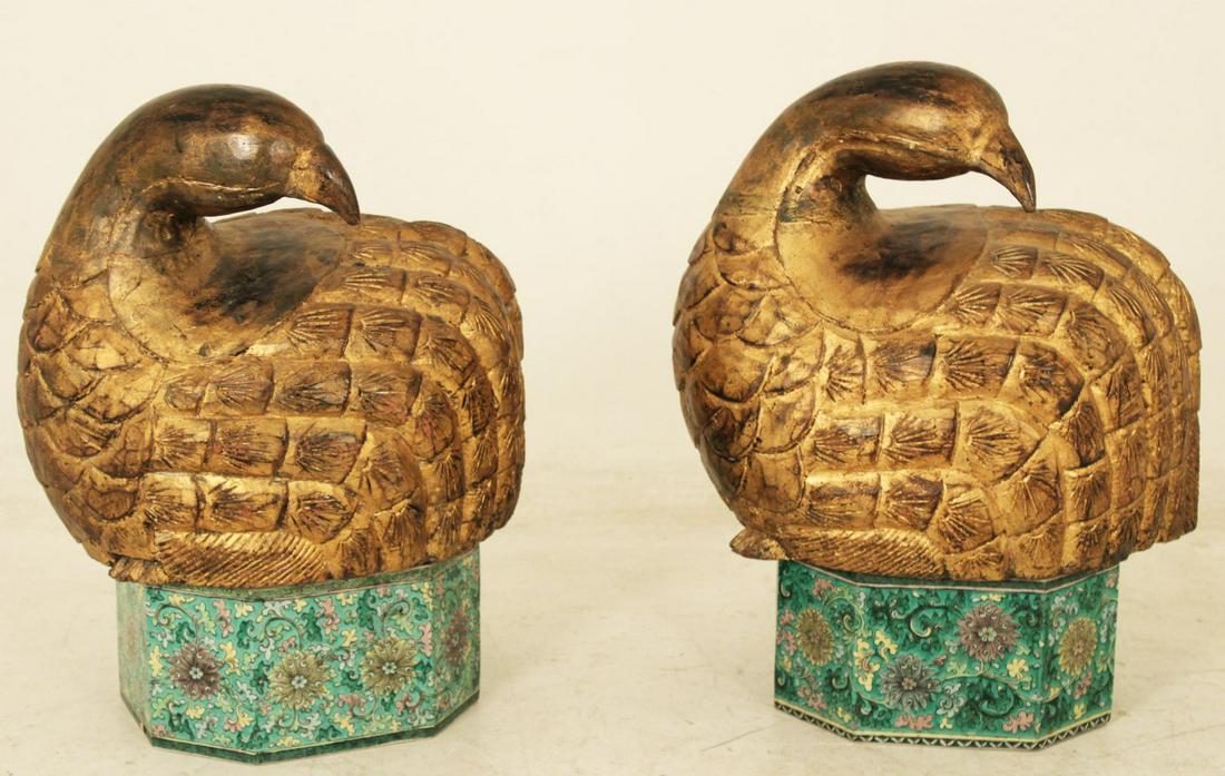 PR OF GOLD GILT ORIENTAL CARVED BIRDS ON PORC. STANDS: INTRIGING PAIR OF GOLD GILT ORIENTAL CARVED WOOD NESTING BIRDS RESTING ON FLORAL DECORATED CHINESE PORCELAIN OCTAGON FORMED STANDS; 4 PCS TOTAL; 21"H X 20.5"W X 15"D BIRDS ONLY, 7.5"H X 14"W X 12"D ST