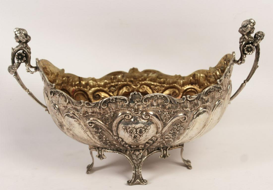 CONTINENTAL SILVER RIBBED FORM CENTERPIECE; 61.9 T.O.W: CONTINENTAL SILVER OVOID SHAPED CENTERPIECE WITH RIBBED FORM BODY, ROCAILLE RELIEF WITH "C" SCROLL AND SHELL LIP, SUPPORTED BY CARYATID HANDLES WITH FESTOON MOUNTS; VERMEIL WASHED LINING; STAMPED 800 
