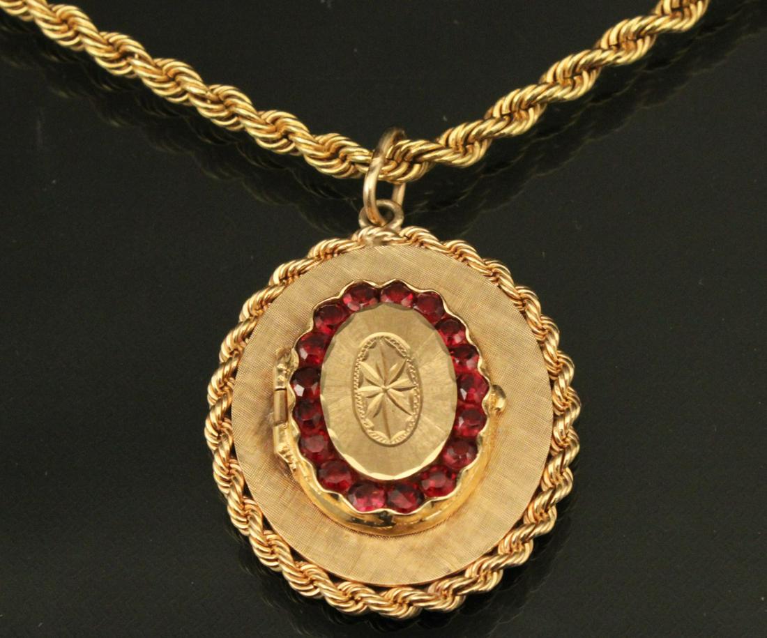18K YG 40" BRAIDED ROPE CHAIN WITH A 14K GOLD OVAL: 18K YELLOW GOLD 40" BRAIDED ROPE CHAIN WITH A 14K GOLD OVAL LOCKET HAVING 17 GARNETS TOTALING APPROX. 2.0 CTW; 18K CHAIN 33.4 GRAMS, 14K PENDANT 20.1 GRAMS