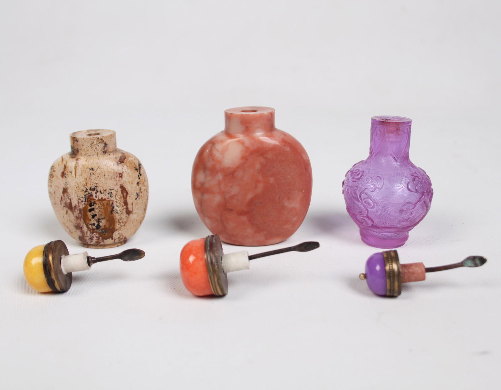 GROUP OF 3 MISC. CHINESE SNUFF BOTTLES: GROUP OF 3 MISCELLANEOUS CHINESE SNUFF BOTTLES CONSISTING OF A 2.75" CHINESE NATURAL ART JASPER SNUFF BOTTLEE WITH YELLOW PEKING GLASS TOPPER AND BRASS SPOON, 1875-1920; A 3.25" CHINESE NATURAL PINK J