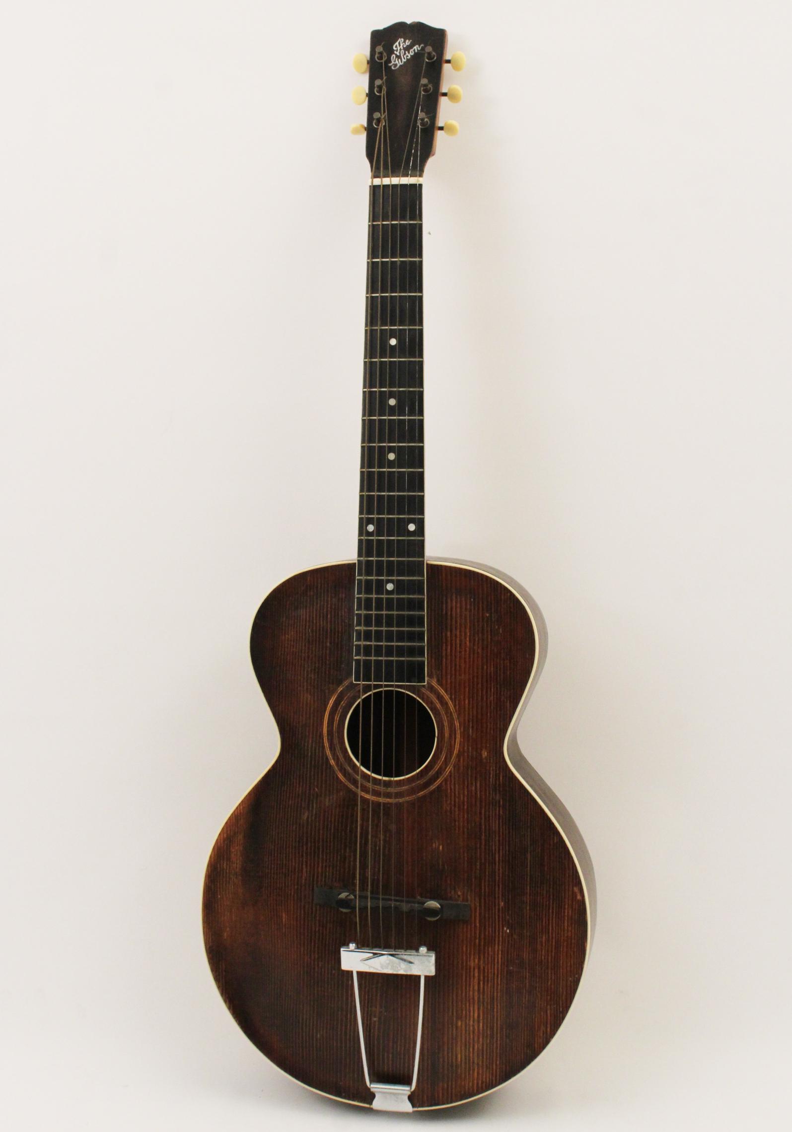 Gibson L-1 acoustic guitar: Circa 1921, natural finish body, missing pick guard with moderate surface wear; 39"H 13.5"W 3"D