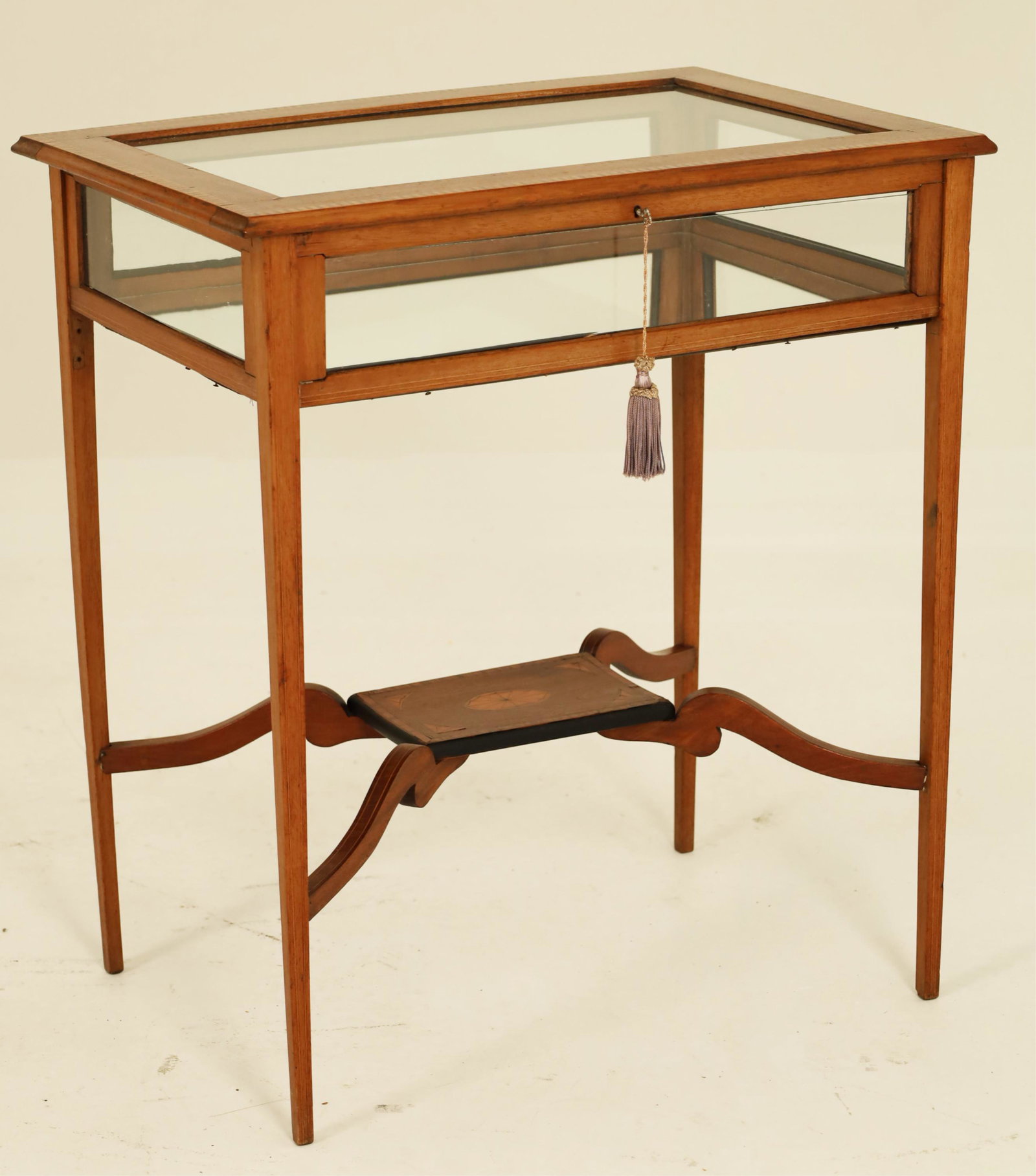 English Edwardian Satinwood Specimen Table: English Edwardian satinwood specimen table with checker board and tulipwood banded top resting on tapered legs with fan inlaid platform stretcher; with key; 28"H 25.25"W 17"D