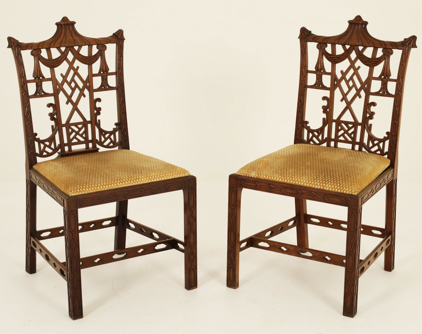 Pair of Chinese Chippendale Design Mahogany Chairs: Pair of Chinese Chippendale design mahogany chairs having pagoda shaped crest rails with swag draped and lattice work backs resting on straight legs with pierced under stretchers; 39.5"H 20.5"W 21"D, 