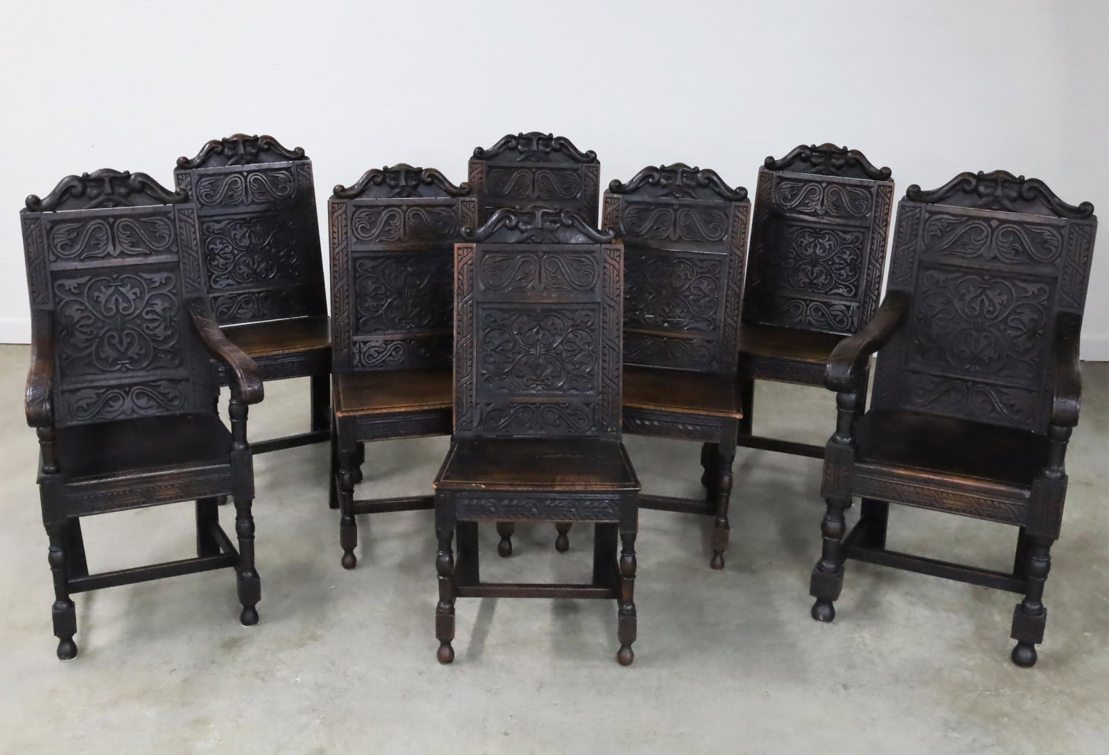 6 & 2 English Renaissance Revival Oak Chairs: Set of 6 and 2 English Renaissance revival oak chairs having carved backs and seat rails with plank seats resting on "H" shaped cross stretchers, 19th C.; 44"H 22.5"W 23"D; condition: losses to plank 