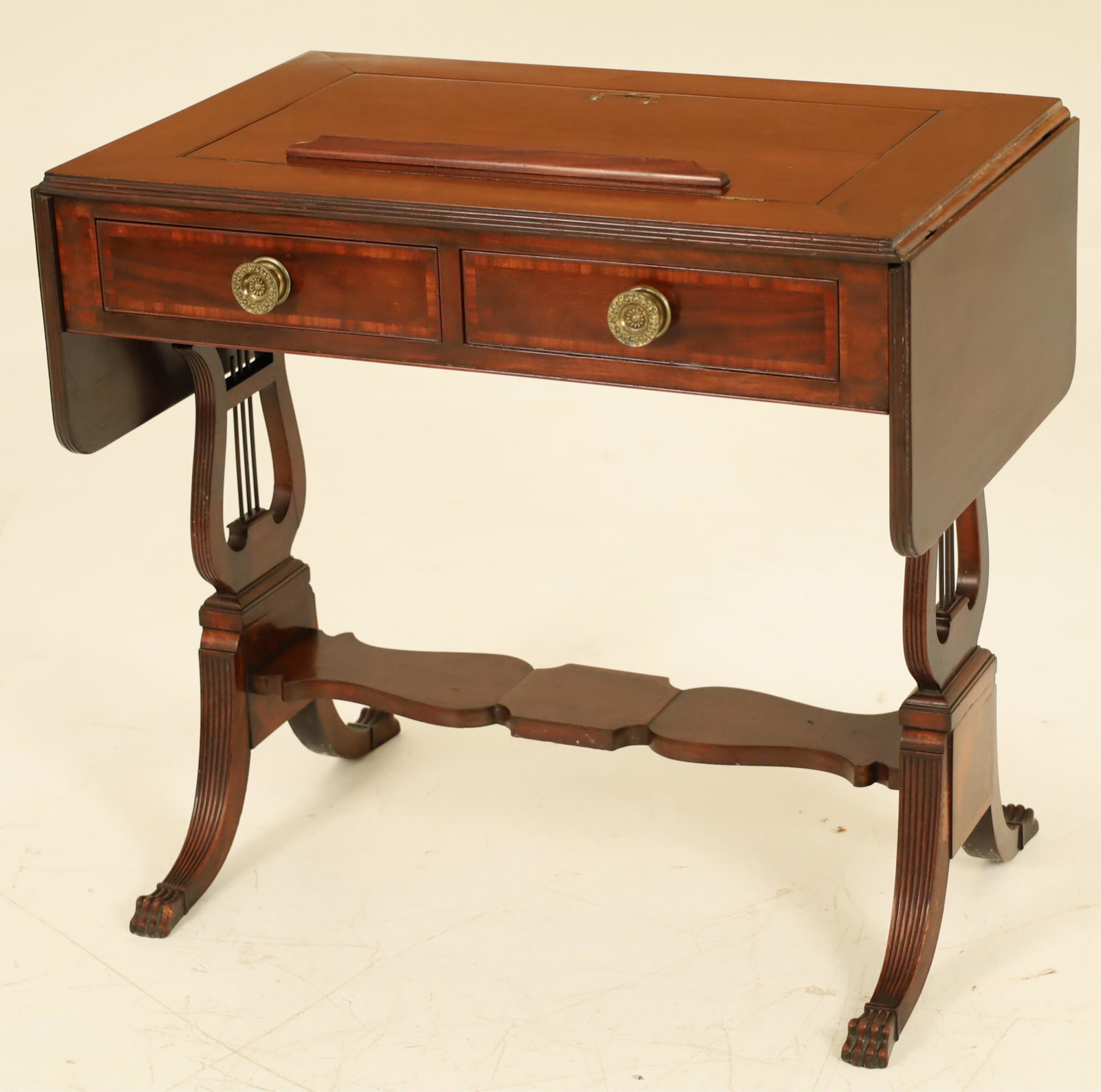 American Duncan Phyfe Architects Table,19th C.: American mahogany Duncan Phyfe architects sofa table having lift top reading stand over a two drawer frieze resting on a lyre formed supported stand with platform stretcher and claw feet, 19th century