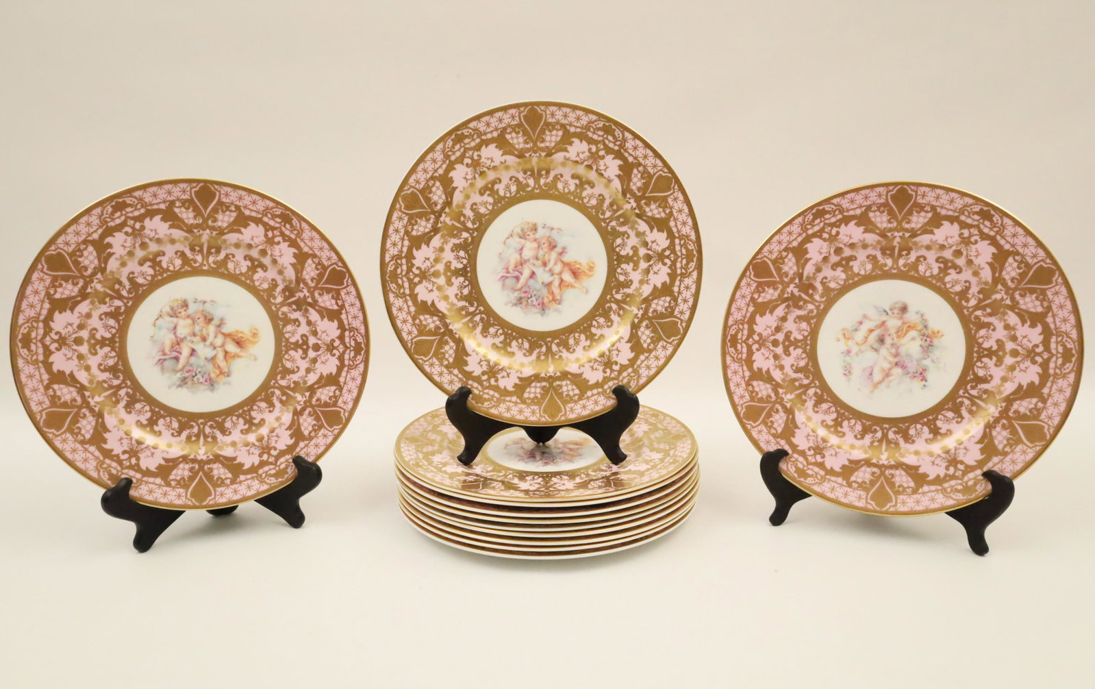 Set of 12 Pink Sevres Style Porcelain Plates: Set of 12 pink Sevres style porcelain plates having gold highlights, the center reserve with mythological studies marked on reverse with faux blue interlocking "L's" underglaze; 10.75 Dia.