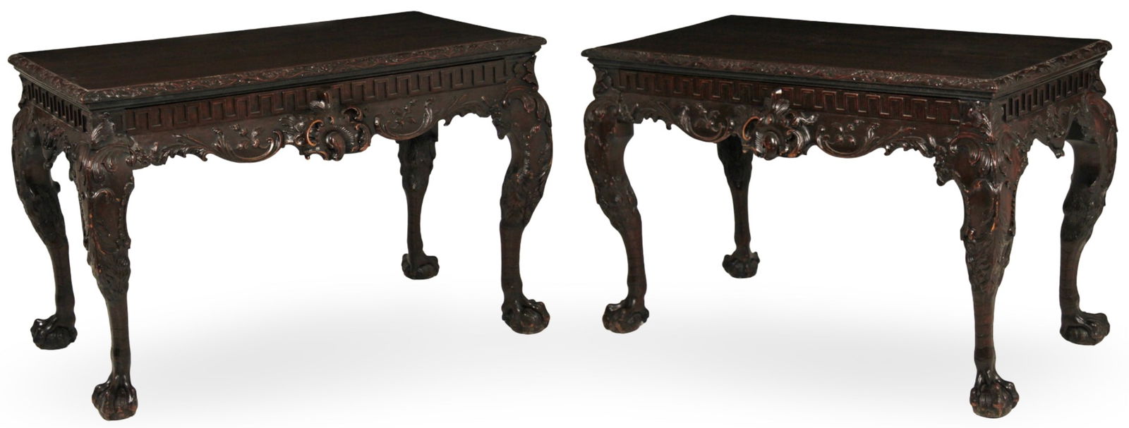 PR IRISH CHIPPENDALE CONSOLE TABLES, 19TH C.: Pair of Irish Chippendale mahogany console tables having foliated leaf C scroll carved edge top over a Greek key frieze with cartouche center medallion drawer resting on acanthus leaf and sheeps head
