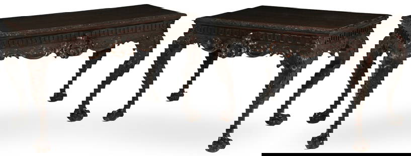 PR IRISH CHIPPENDALE CONSOLE TABLES, 19TH C.: Pair of Irish Chippendale mahogany console tables having foliated leaf C scroll carved edge top over a Greek key frieze with cartouche center medallion drawer resting on acanthus leaf and sheeps head