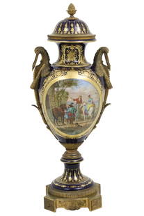 BRONZE MOUNTED SIGNED SEVRES CAPPED URN: Impressive cobalt and gold gilt bronze mounted Sevres porcelain capped revolving urn on stand having central landscape reserve painted with figures on horseback, signed V. Moreau; 43"H 19"W 12" base