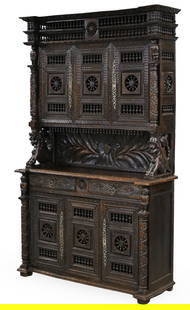 BRITTANY WALNUT BUFFET DEUX CORPS: Brittany region French walnut buffet duex corps, intricately carved with spindlework cornice and cabinet doors, foliated column supports, the center gallery with griffon surmounts and cartouche back r