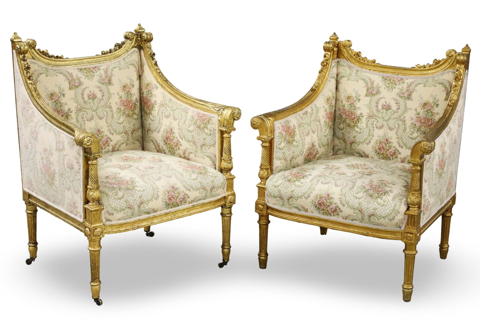 PR LOUIS XVI STYLE GILTWOOD BERGERES: Pair of Louis XVI style giltwood bergeres having ornately carved frames and floral embroidered upholstery, late 19th century; each 37"H 27"W 22.5"D; Condition: one bergere missing its casters