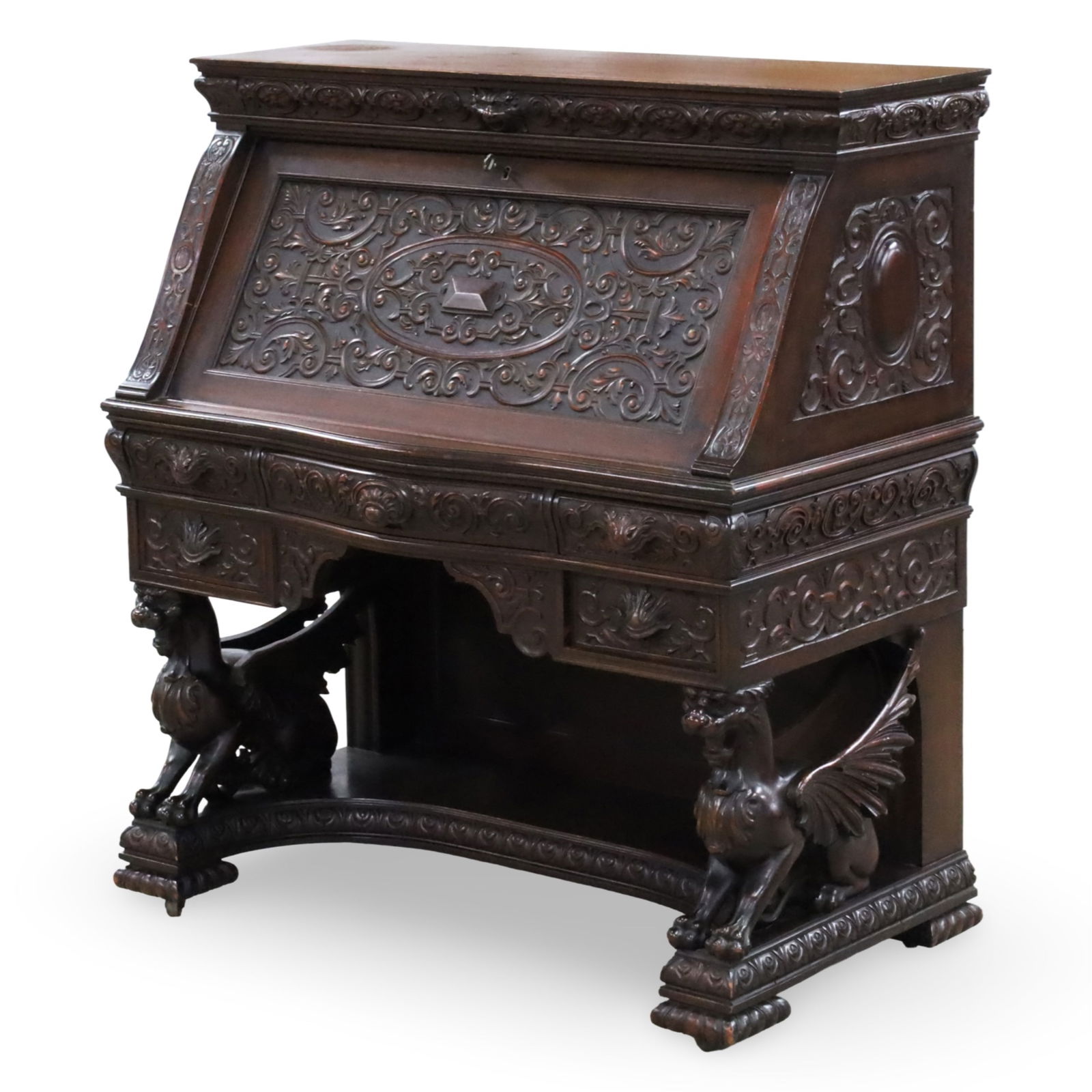 R.J. HORNER (ATTRIB) WINGED GRIFFIN MAHOGANY DESK: American Classical Revival mahogany slant-front desk, attributed to R.J. Horner & Co. (New York, 1886-1915), front panel carved with foliate scrolls, opening to fitted interior gallery with concealed