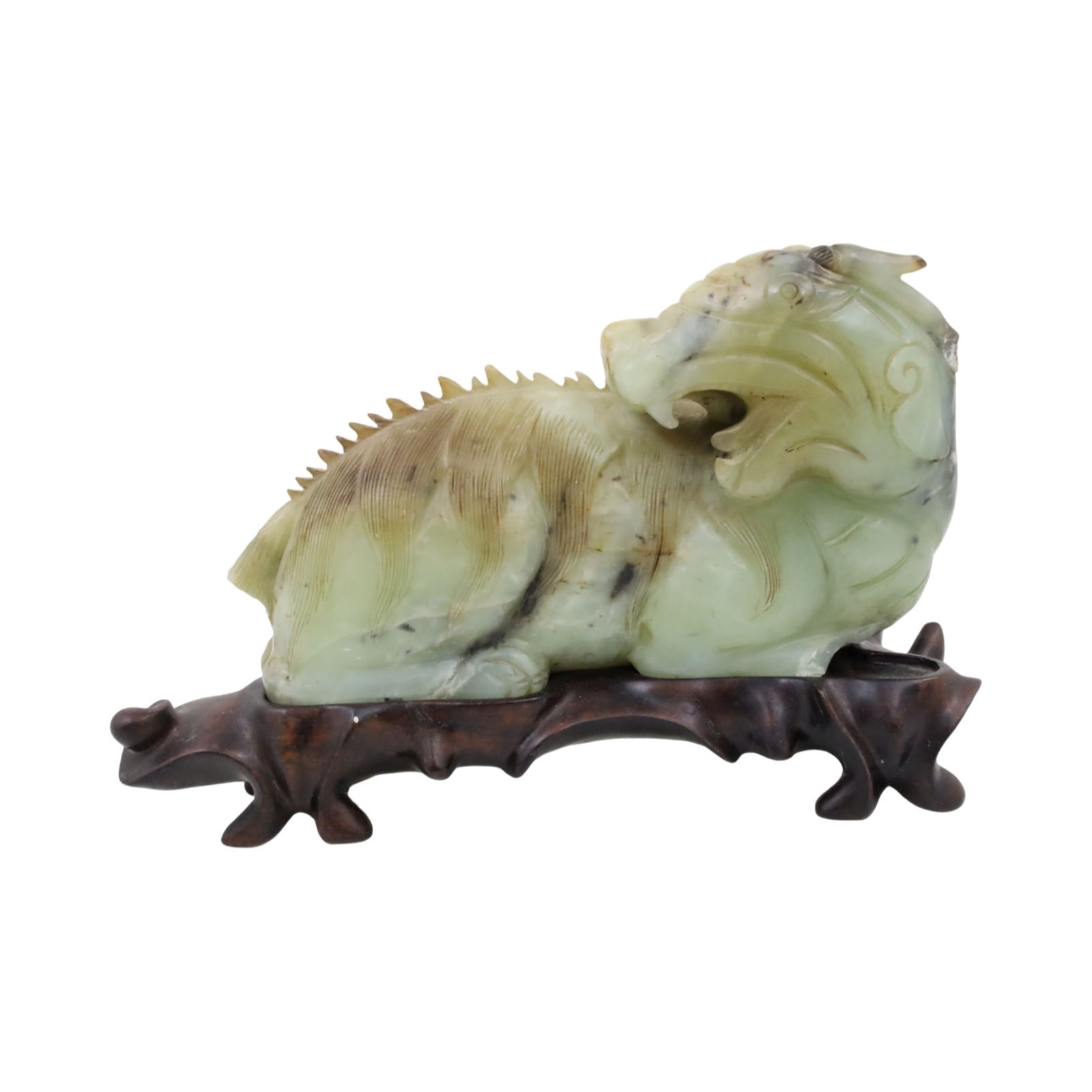 CHINESE JADE FIGURE OF GUARDIAN BEAST: Chinese carved jade figure of a recumbent guardian beast, resting on fitted teakwood stand, early 20th century; 6.5"H 10"W 3"D on stand; Condition: losses to arm and tail