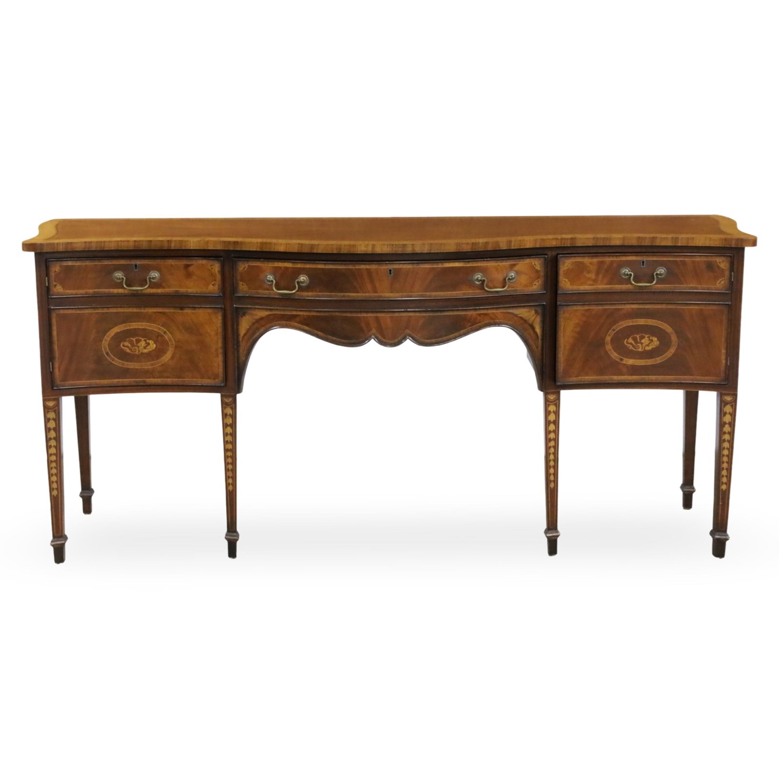 GEORGIAN STYLE INLAID MAHOGANY SIDEBOARD: Georgian style mahogany sideboard, having satinwood crossbanded top, the serpentine front inlaid with shell and fan inlay, tapered legs inlaid and resting on spade feet, 20th century; 37.5"H 83"W 24"D