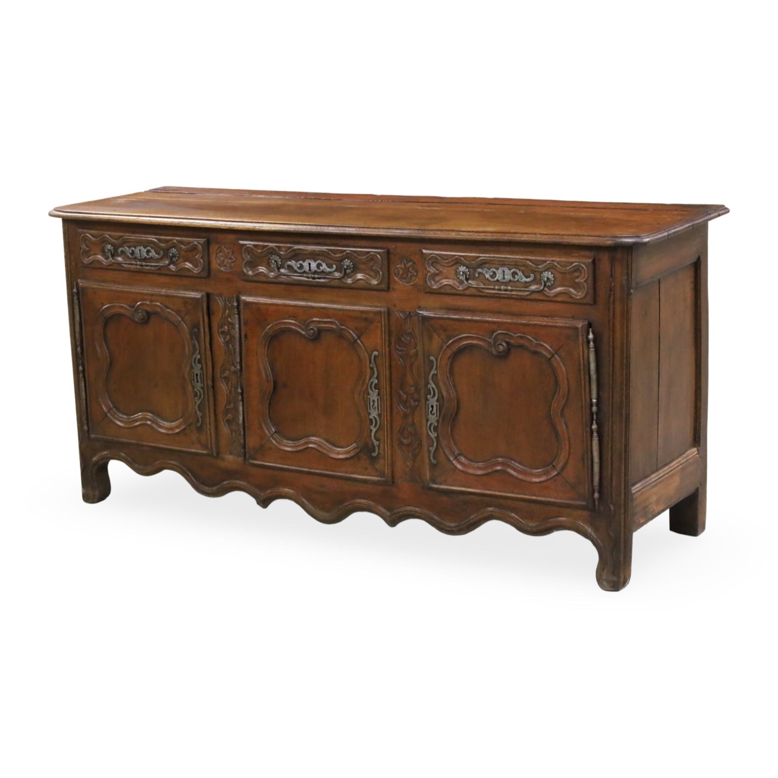 PROVINCIAL FRENCH WALNUT SIDEBOARD, 19TH C.: Provincial French walnut sideboard having triple drawer rosette carved frieze above triple cabinet with shaped panel doors and apron, 19th century; 35"H 74"W 23"D