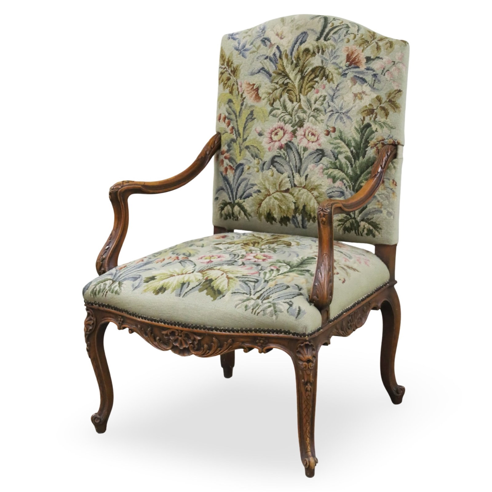 LOUIS XV STYLE NEEDLEPOINT FAUTEUIL, 19TH C.: Louis XV style walnut fauteuil armchair, covered in beautiful floral needlepoint, downswept arms, apron, and legs with finely carved shell and foliate design, late 19th century; 41"H 27"W 23"D