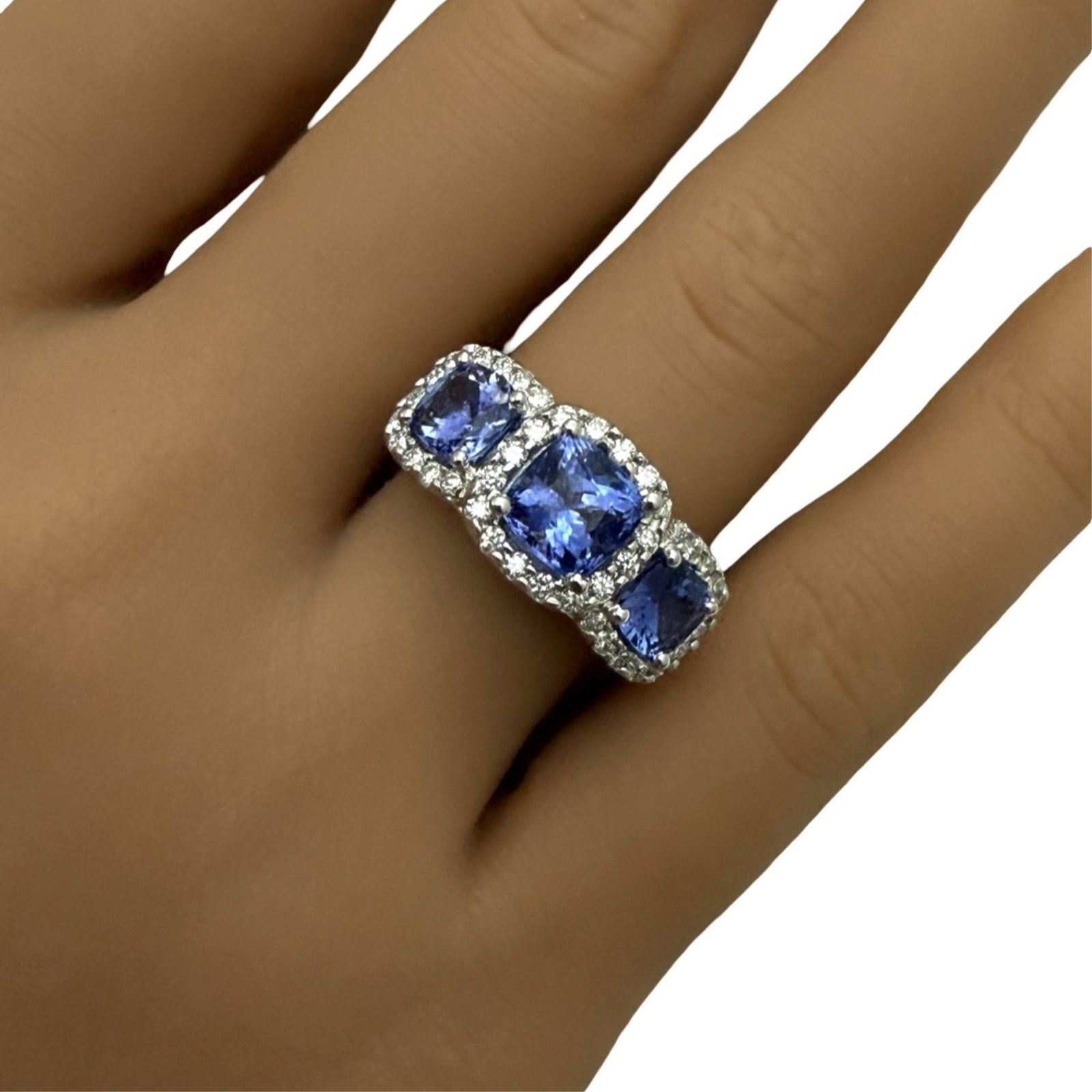 14K TRIPLE TANZANITE AND DIAMOND RING: 14k white gold natural tanzanite and diamond ring with 3 cushion brilliant cut tananites weighing 3.61cts surrounded by .78cts of brilliant round diamonds. gross weight 6.5grams .size 6.5. Please see