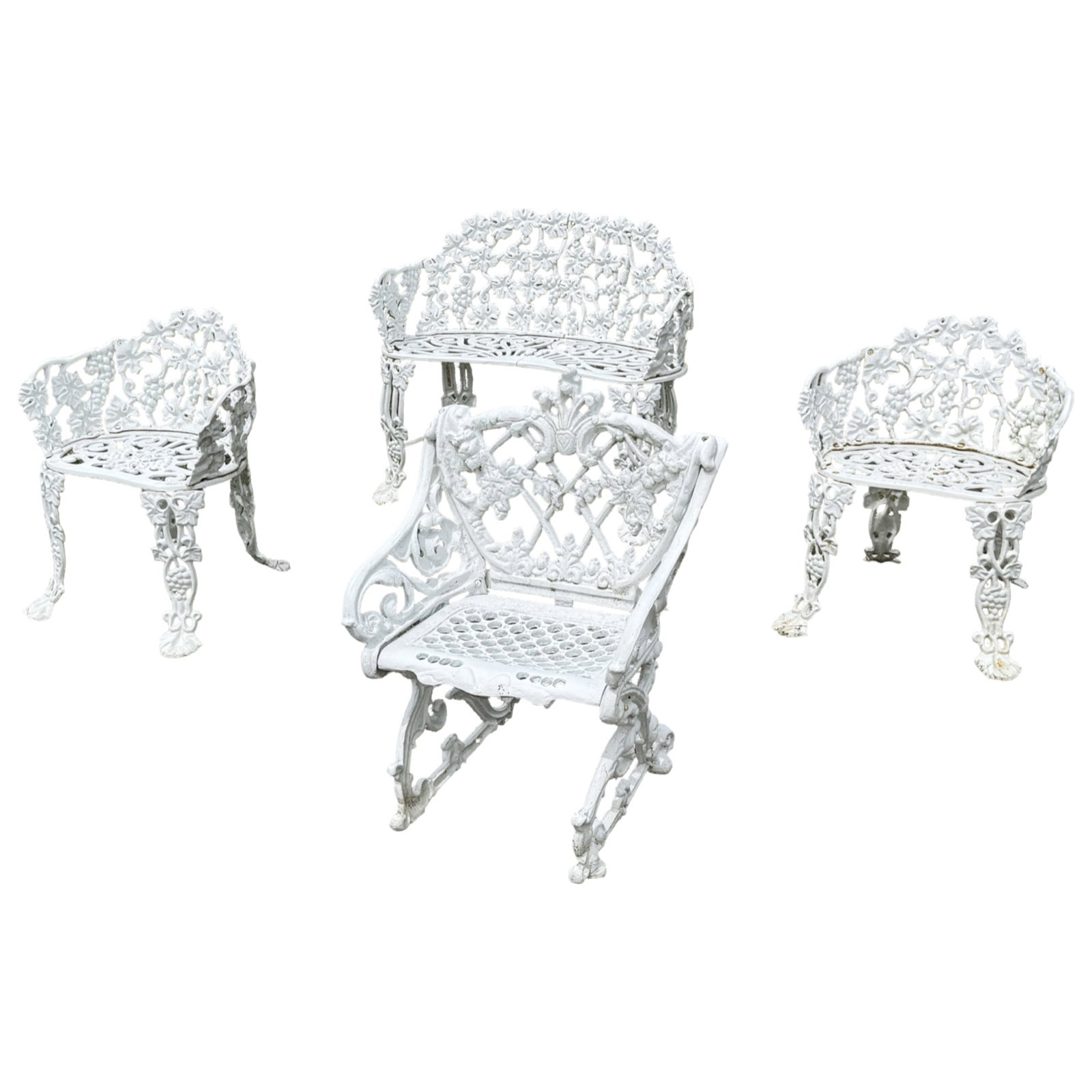 4PC SET OF VICTORIAN CAST IRON GARDEN SEATING: Four piece set of Victorian cast iron garden seating, including a matching pierced grape and foliate settee with pair of chairs, along with a complimentary armchair with elaborate shell crest rail,