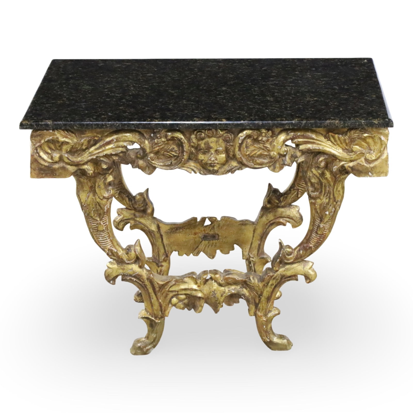 ITALIAN GILTWOOD MARBLE TOP CONSOLE: Italian giltwood low console with black marble top, apron decorated with angel mask and foliate carvings, early 20th century; 22.5"H 30"W 22"D