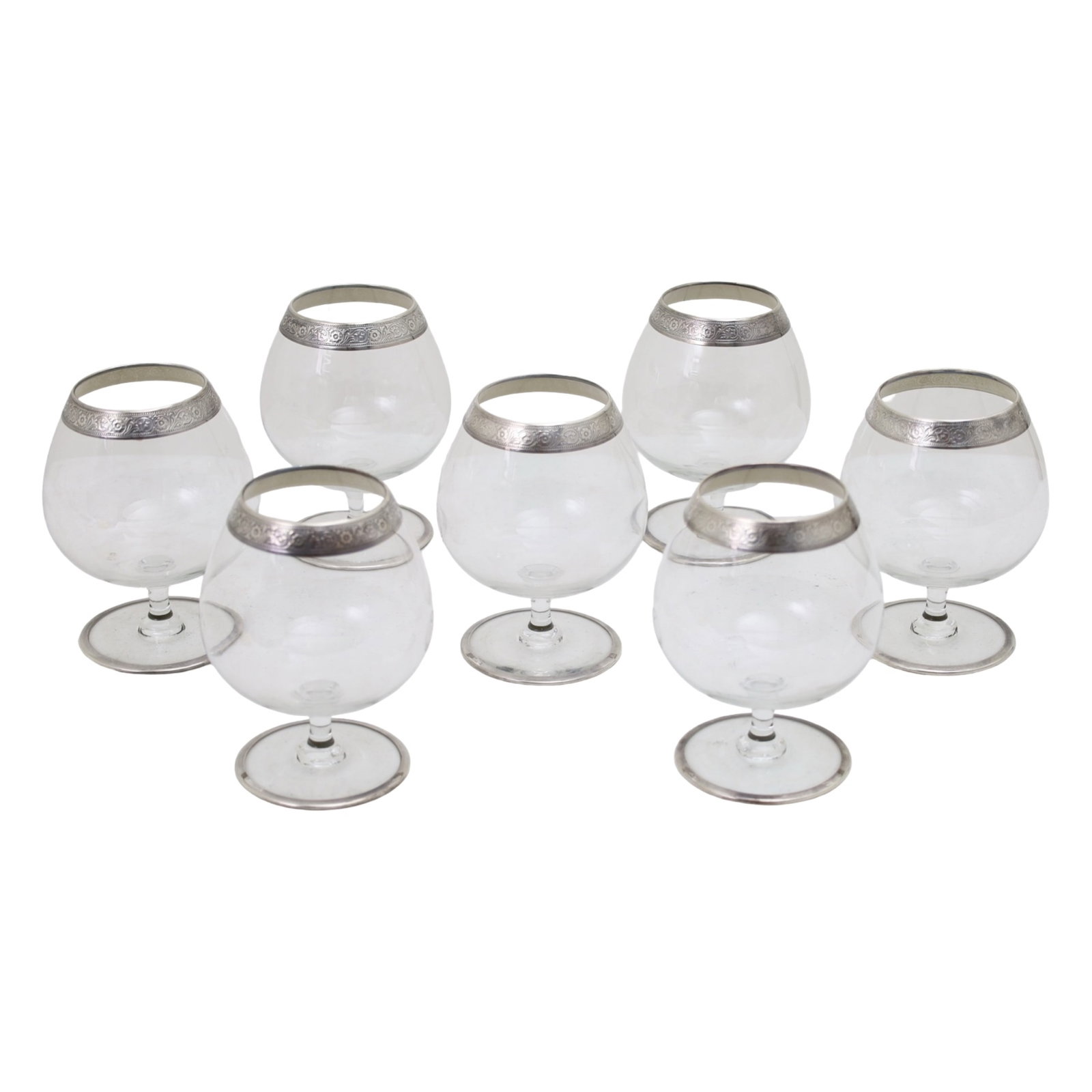 SET OF 7 SILVER LINED BRANDY SNIFTER GLASSES: Set of seven sterling silver lined brandy snifter glasses, raised floral relief at lip, marked sterling on foot; 5.5"H; Condition: hooked hairline observed to one glass, see photo