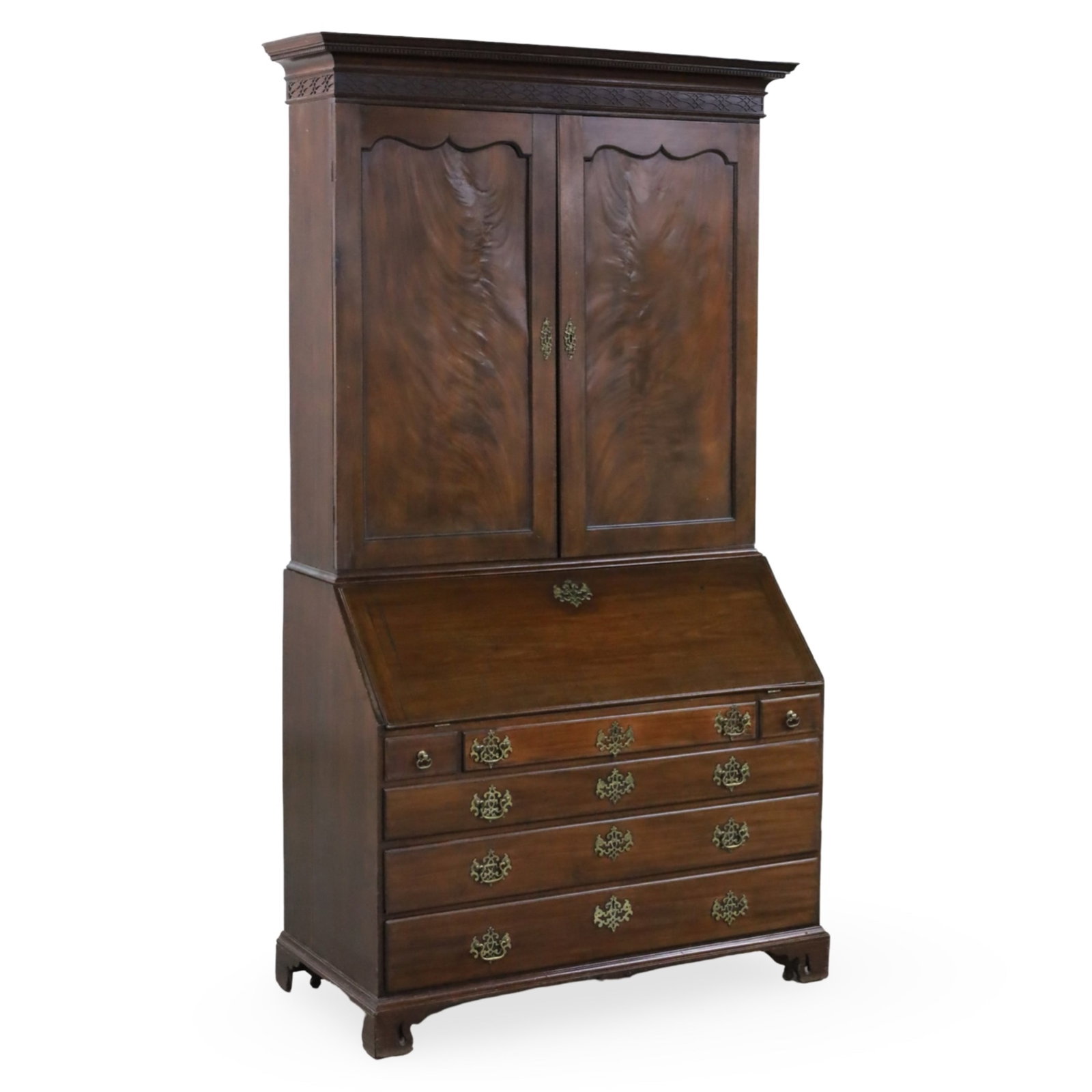 GEORGIAN MAHOGANY SECRETARY BOOKCASE, 19TH C.: Stately Georgian mahogany bookcase having a dentil molded cornice and fretwork frieze, the upper cabinet with shaped paneled doors, lowering to a fall front secretary drawer and six additional drawers