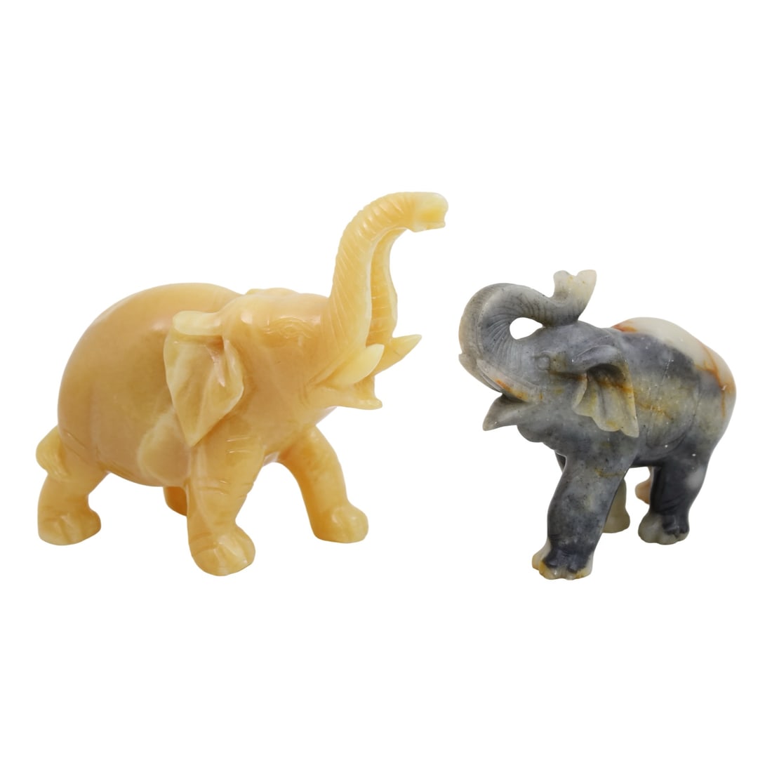 TWO CHINESE CARVED STONE ELEPHANTS: Group of two Chinese carved stone elephants, the larger in yellow jade, the other in Kisi soapstone; largest 7"H 8"L