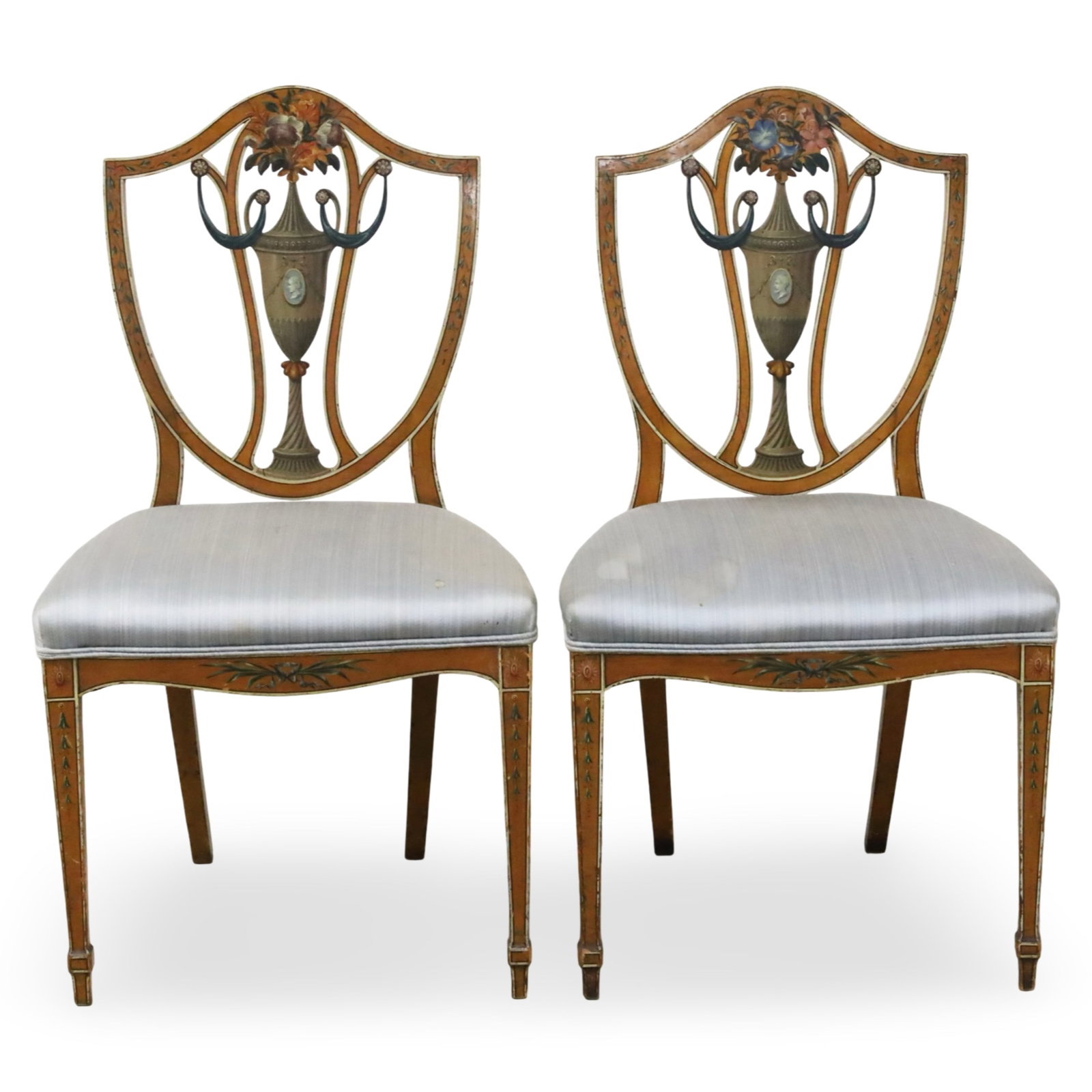 PR HEPPLEWHITE STYLE SATINWOOD SIDE CHAIRS: Pair of Hepplewhite style satinwood armchairs having shield backs with painted urn and floral decoration raised on tapered legs with spade feet, late 19th century; 36"H 21"W 16"D