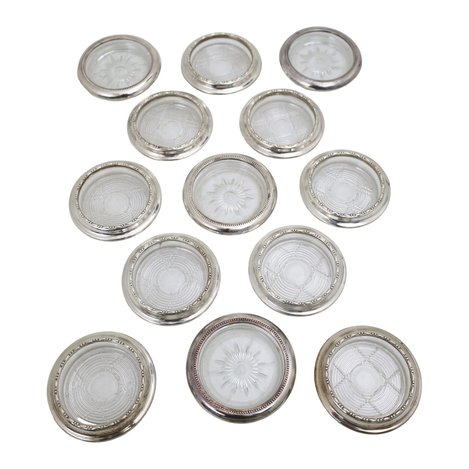 12PC SET OF SILVER LINED CUT CRYSTAL COASTERS: Twelve piece harlequin set of silver lined cut crystal coasters, eight marked Amstom sterling, four marked Leonard Italy silverplate; 4" Diameter