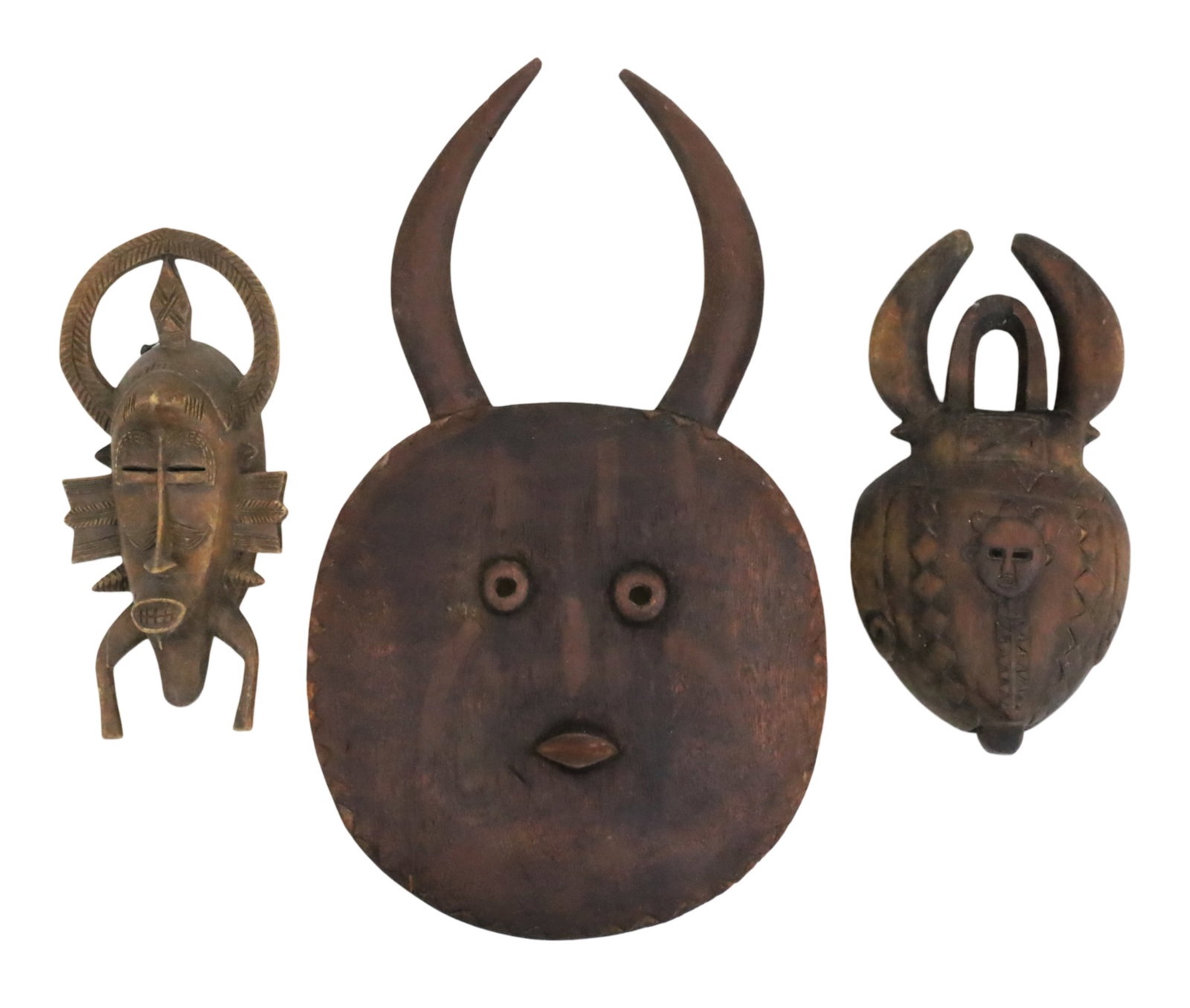 THREE WEST AFRICAN TRIBAL MASKS: Group of three West African tribal masks, including large a Baule Goli mask, along with a Senufo carved mask featuring an elongated face with teeth bared and fin or wing-like protrusions, and another 