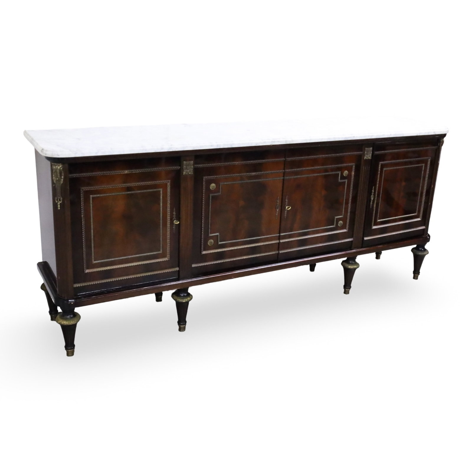 LOUIS XVI STYLE ENFILADE SIDEBOARD: Louis XVI style enfilade sideboard having variegated white marble top, mahogany case with bronze rosette accents and trim paneled cabinets doors, flanking cabinet with fitted interior, raised on
