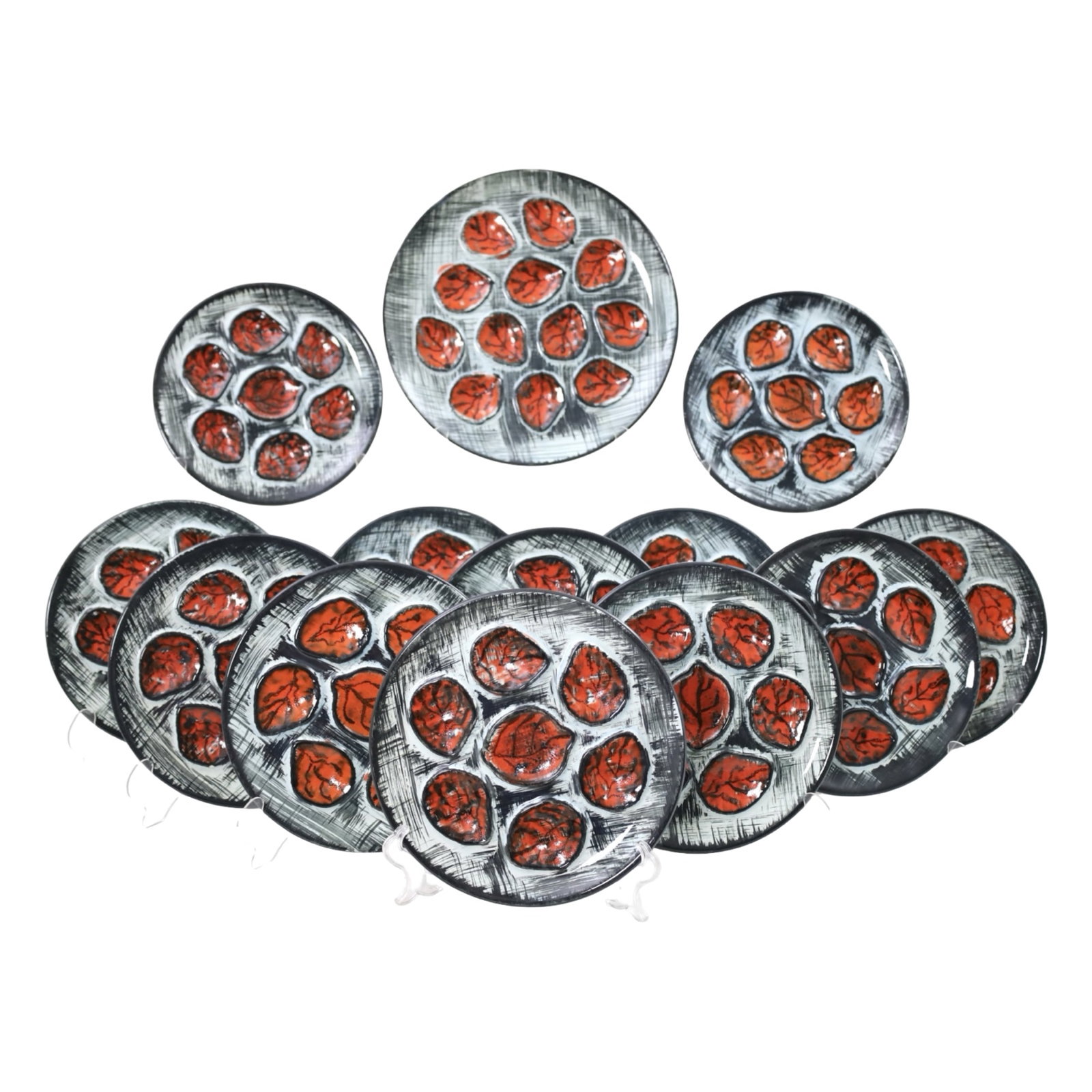 FRENCH HAND PAINTED OYSTER PLATE SERVICE: French hand painted oyster plate service comprising twelve plates and one large platter. Each piece decorated with stylized oyster shells in vibrant red and black tones against a textured gray ground.