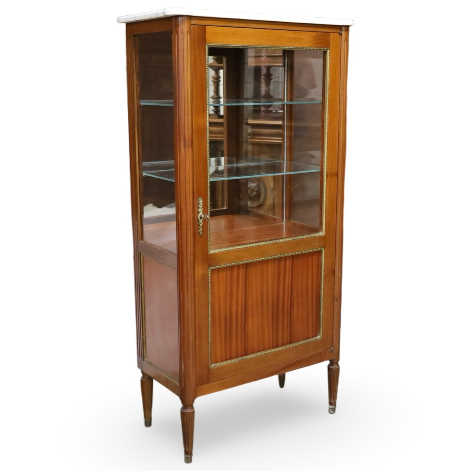 FRENCH MAHOGANY MARBLE-TOP VITRINE: French Louis XVI style mahogany vitrine with a white marble top above a glazed door opening to an upper display compartment fitted with two glass shelves and a lower cabinet fitted with two wooden she