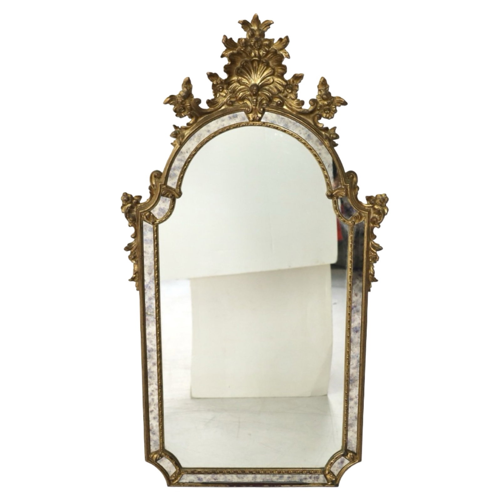 ITALIAN GILTWOOD WALL MIRROR: Italian Rococo Revival giltwood wall mirror with shaped crest featuring acanthus and shell ornament above an arched mirror plate. The frame is accented by a mirrored border with gilt beaded molding an