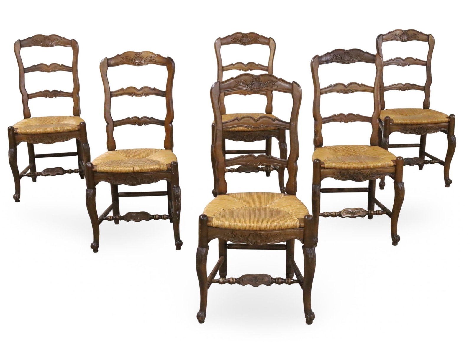 SET OF 6 COUNTRY FRENCH WALNUT LADDER BACK CHAIRS: Set of six country French walnut ladder back chairs, crest rail and apron with carved shell motifs, having rush seats, raised on cabriole legs with turned floral carved stretchers; each 39"H 18"W 15"D