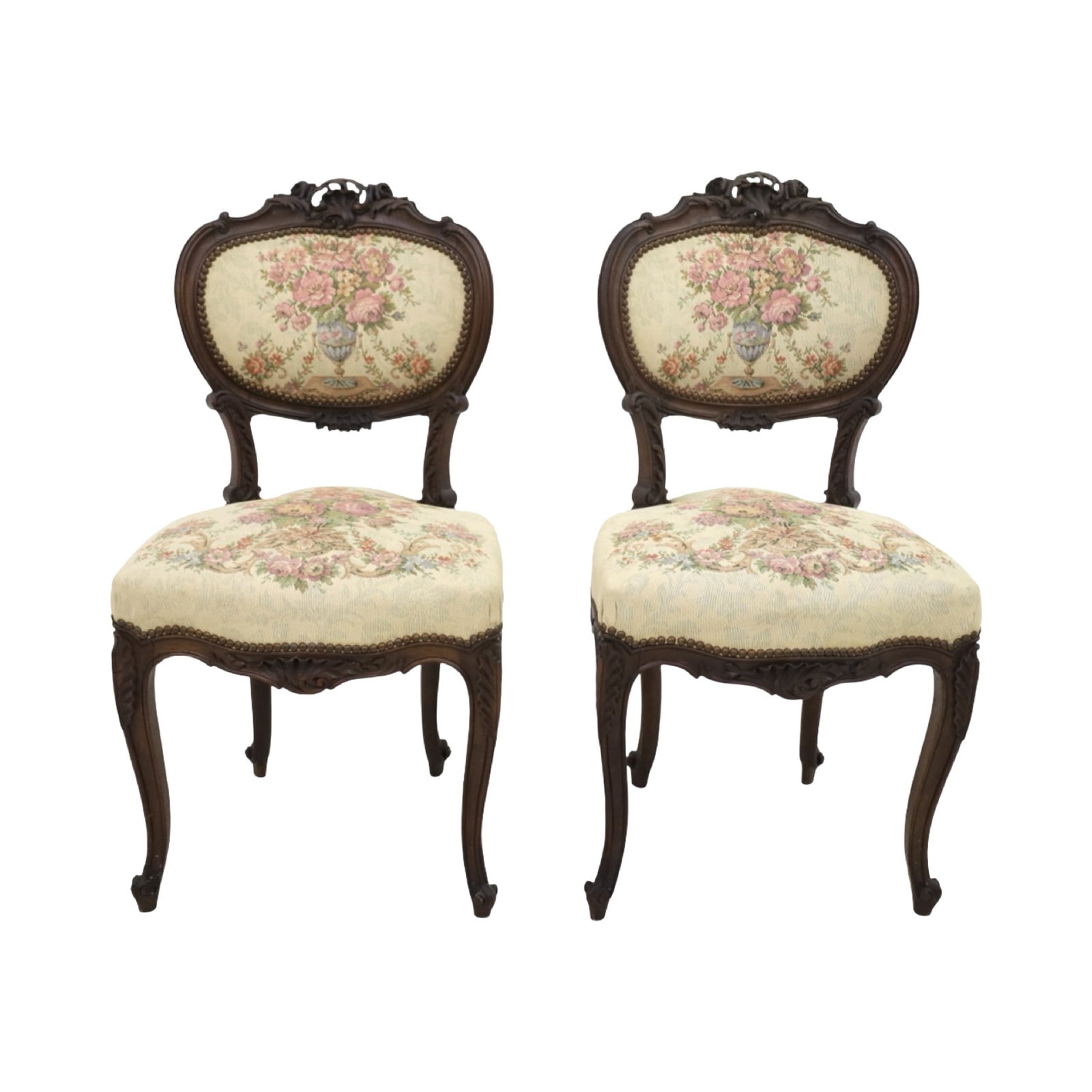 PETITE LOUIS XV STYLE NEEDLEPOINT CHAIRS: Carved walnut Louis XV-style side chairs, each with shaped crest rail, floral carving, cabriole legs, and upholstered in floral needlepoint featuring urns of flowers. Brass tack trim throughout.