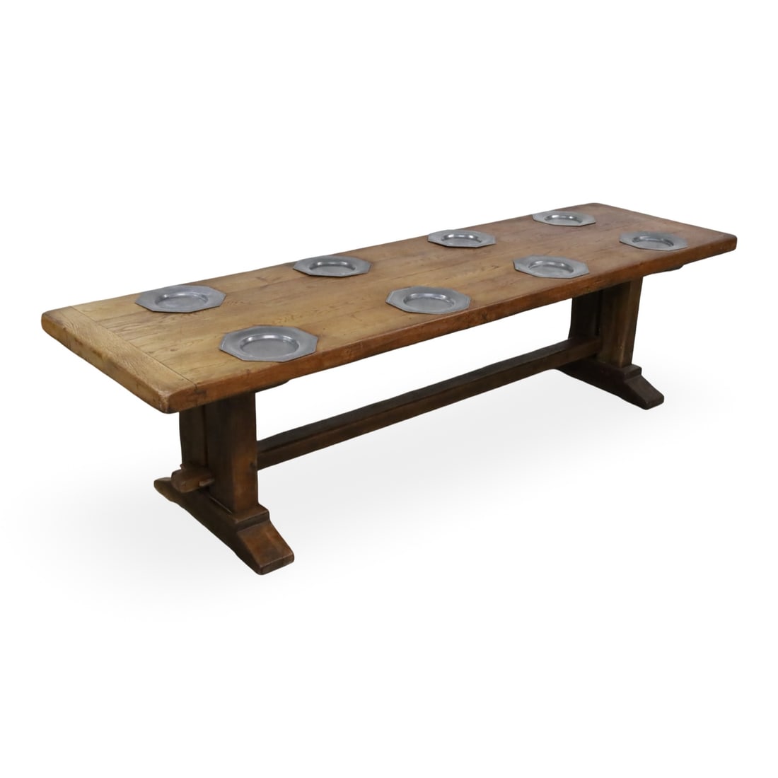 FRENCH OAK PEWTER INSET MONASTERY TABLE: French oak monastery table, having breadboard end solid plank top with carved inserts for 8 pewter chargers, raised on double pedestal with stretcher, early 20th century; 29"H 32"W 110"L