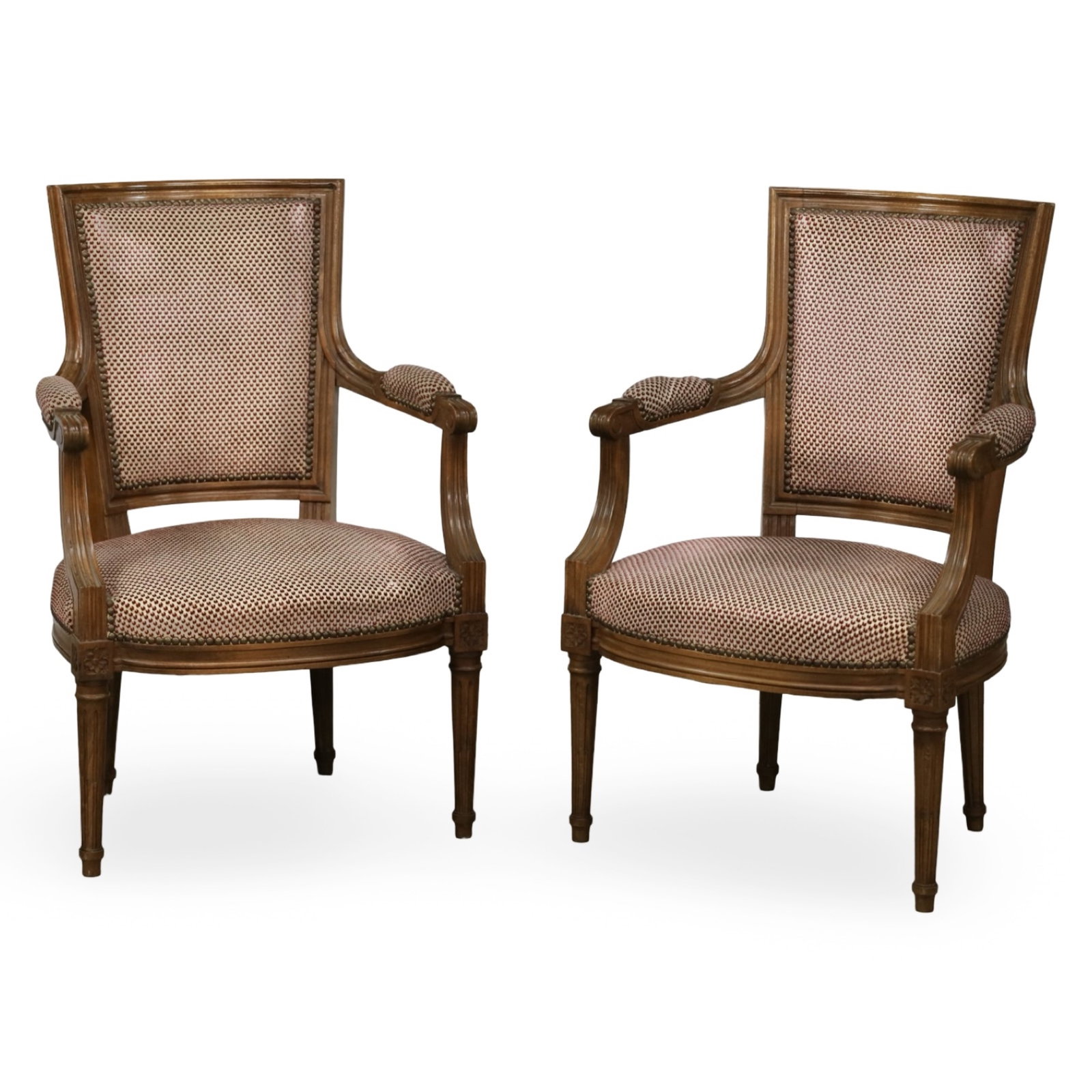 PAIR OF FRENCH LOUIS XVI STYLE FAUTEUIL ARMCHAIRS: Pair of French Louis XVI style walnut fauteuil armchairs with upholstered seats and backs, fluted legs and scrolling arms. Measures 22"W x 18.5"D x 34"H.