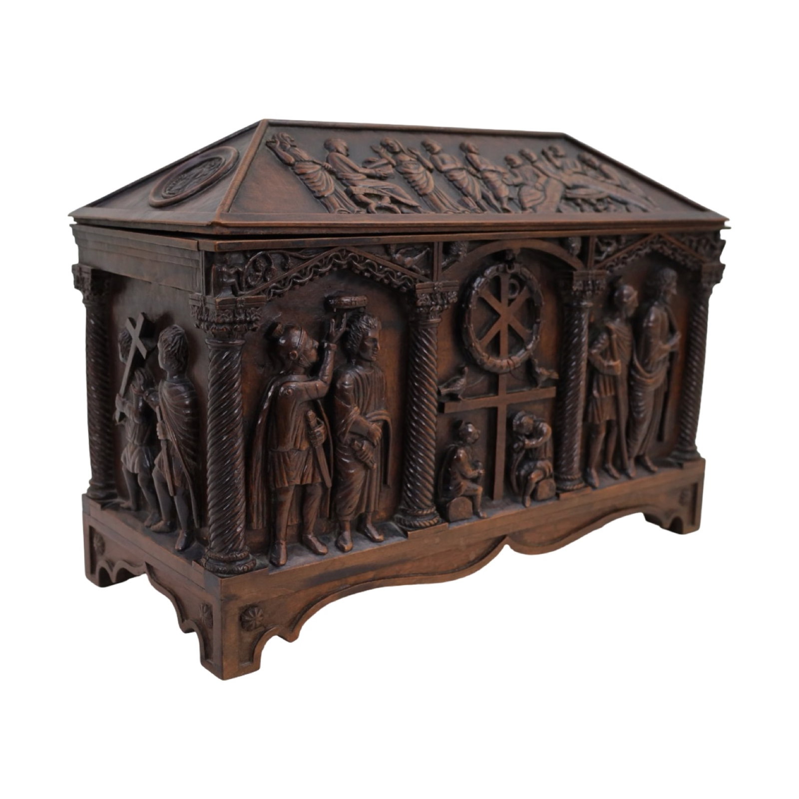 CARVED RELIGIOUS WALNUT CASKET FORM BOX: Finely carved walnut casket-form box having a hinged lid with deeply carved figural and biblical relief decoration throughout. The sloping lid depicts religious scenes in high relief, while the sides