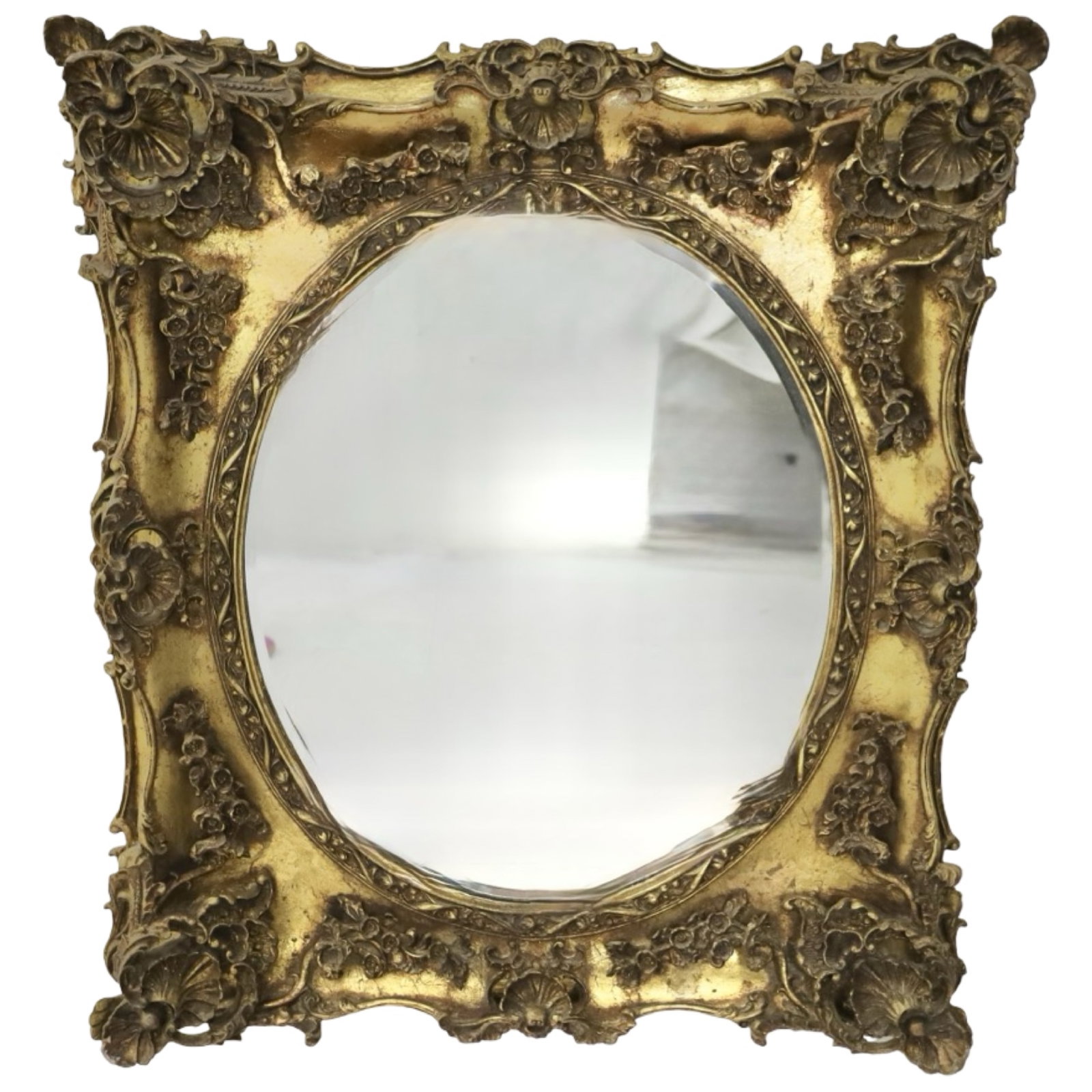 FRENCH ROCOCO GILTWOOD MIRROR: French Rococo Revival giltwood mirror with shaped rectangular frame, molded oval mirror plate, and carved shell, floral, and foliate decoration.30" W x 34" H.