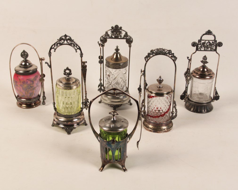 GROUP OF 6 MISCELLANEOUS SILVER FRAMED PICKLE CASTERS: GROUP OF 6 MISCELLANEOUS SILVER FRAMED PICKLE CASTERS, 3 CUT GLASS, 1 VASELINE GLASS AND A SIMILAR GREEN GLASS, AND 1 PINK SATIN GLASS, ALL WITH EITHER TONGS OR FORK; 13"H TALLEST, VASELINE GLASS
