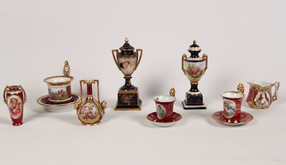 11 PIECE MISCELLANEOUS LOT OF HAND PAINTED PORCELAIN: 11 PIECE MISCELLANEOUS LOT OF VIENNA AND VIENNA STYLE HAND PAINTED PORCELAIN INCLUDING 2 COBALT GROUND CAPPED CABINET URNS, 2 VASES, 3 CUPS AND SAUCERS AND A CREAMER; 9"H TALLEST URN; CONDITION: LID T