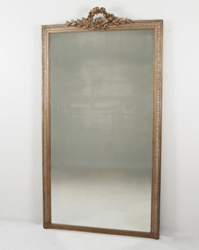 PALACIAL 19TH C. FRENCH GESSO AND WOOD GILDED GOLD LEAF: PALACIAL 19TH C. FRENCH GESSO AND WOOD GILDED GOLD LEAF MIRROR HAVING QUIVER AND TORCH WREATH CARVED CREST; 92"H X 50.5"W; CONDITION: HAS BEEN PROFESSIONALLY RE-BACKED FOR HANGING PURPOSES