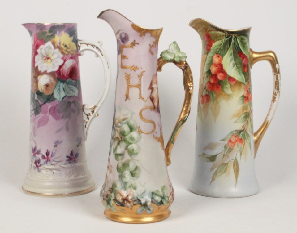 GROUP OF 3 HAND PAINTED LIMOGES PORCELAIN PITCHERS: GROUP OF 3 HAND PAINTED LIMOGES PORCELAIN PITCHERS, ALL MARKED ON REVERSE, ONE SIGNED EMILE; 15.5"H TALLEST; CONDITION: WEAR TO GOLD ON HANDLES