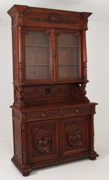 EUROPEAN CARVED OAK BOOKCASE: EUROPEAN CARVED OAK BOOKCASE WITH OVAL CARVED PANEL DOORS DEPICTING DOGS IN A NATURALISTIC SETTING, 19TH C.; 101"H X 56"W X 24"D
