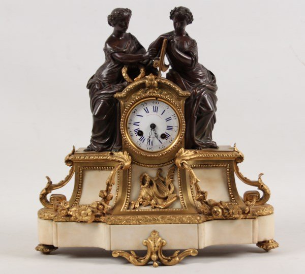 FRENCH DORE BRONZE AND MARBLE CLOCK: FRENCH DORE BRONZE AND CREAM MARBLE CLOCK HAVING CLASSICALLY DRAPED FEMALE FIGURES HOLDING SCROLL, LATE 19TH C.; 16"H X 15"W X 5"D; CONDITION: MISSING BEZEL